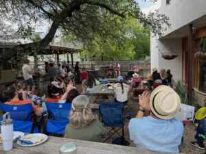 Group of neighbors in a backyard watching the talent show.